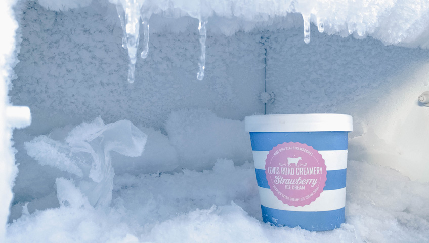 Ice cream container with cold-resistant label surrounded by ice in freezer.