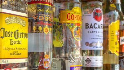 Close-up of a variety of liquor bottles with colorful labels--tequila, rum, gin, vodka.