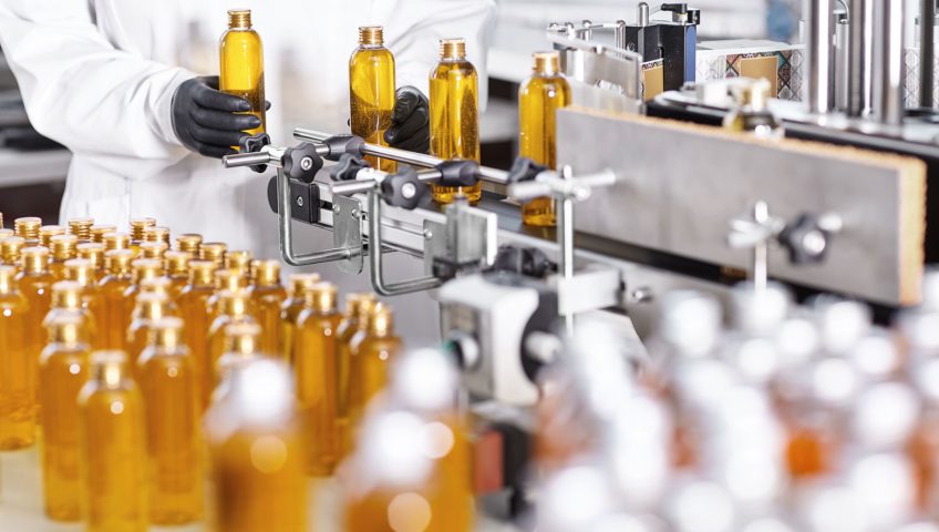 Bottles about to enter an automatic label applicator.