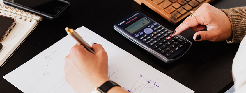 Business owner doing calculations to figure cost of custom product labels.