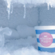 Ice cream container with cold-resistant label surrounded by ice in freezer.