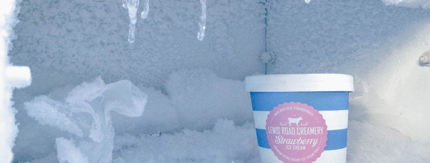 Ice cream container with cold-resistant label surrounded by ice in freezer.