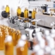 Bottles about to enter an automatic label applicator.