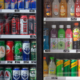 Facing side of a two-door cooler, filled with labeled cans and bottles.