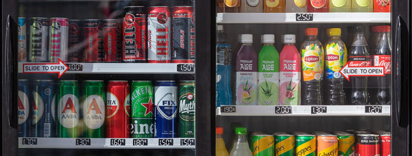 Facing side of a two-door cooler, filled with labeled cans and bottles.
