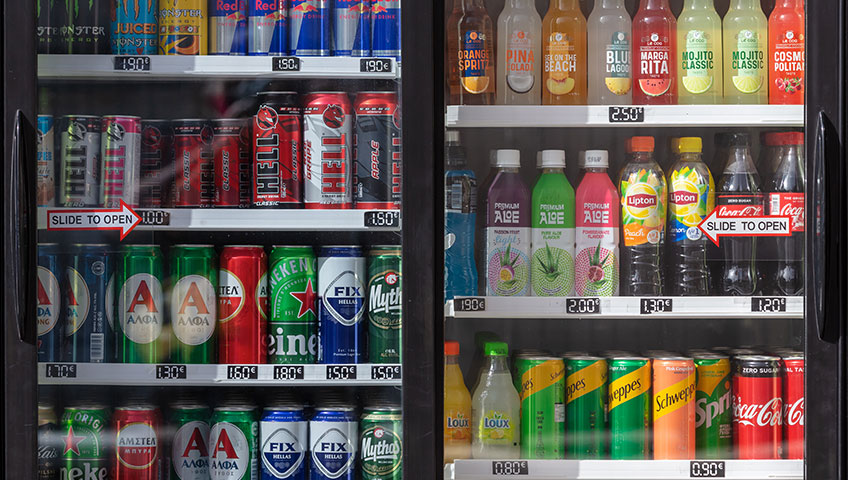 Facing side of a two-door cooler, filled with labeled cans and bottles.