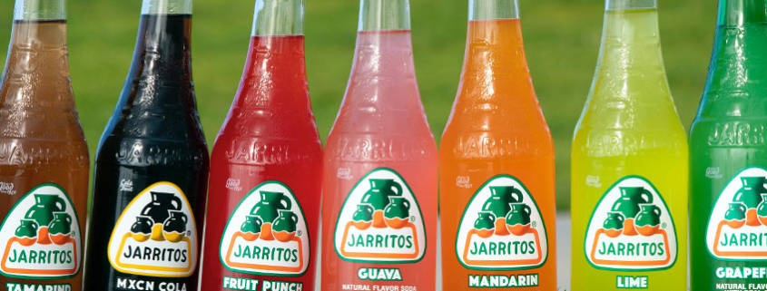 Jarritos labeled craft soda bottles in a straight line.
