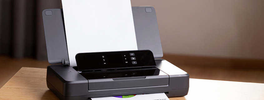 Close-up of a laser printer and a freshly printed page.